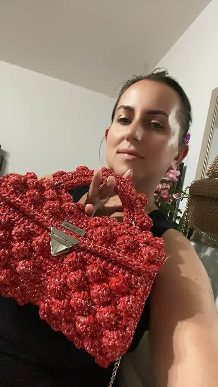 Kobieta trzymająca czerwoną torebkę z makramy